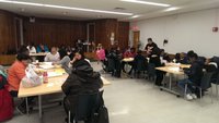 People gather around tables in a large meeting hall