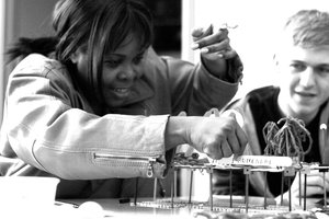 Woman smiles as she labels the "promenade" structure she built out of small objects