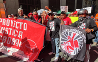 Marchers carry banners reading "Delivery Workers United"