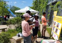 A group of people stand outside working on large posters at a pop-up placemaking workshop 