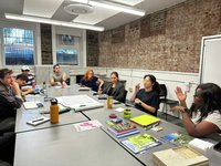 A class discussion with about eight people sitting around a table